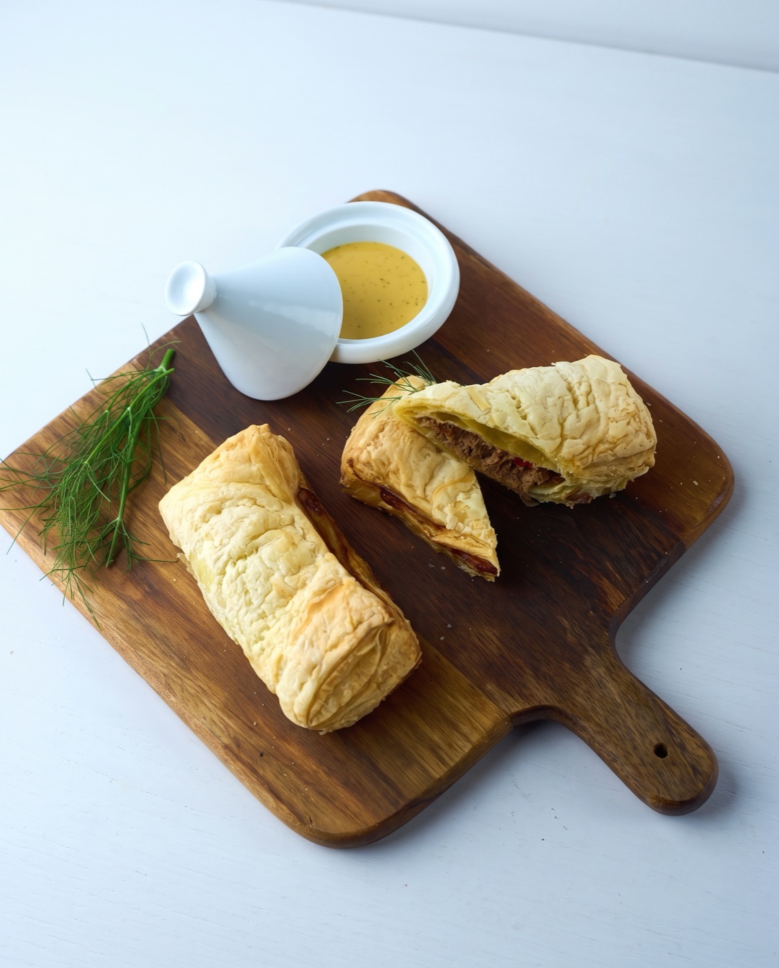 Shredded beef empanada cut open, with dipping sauce