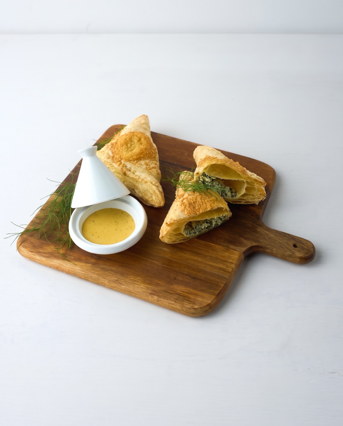 Ricotta and spinach empanadas on a wooden board
